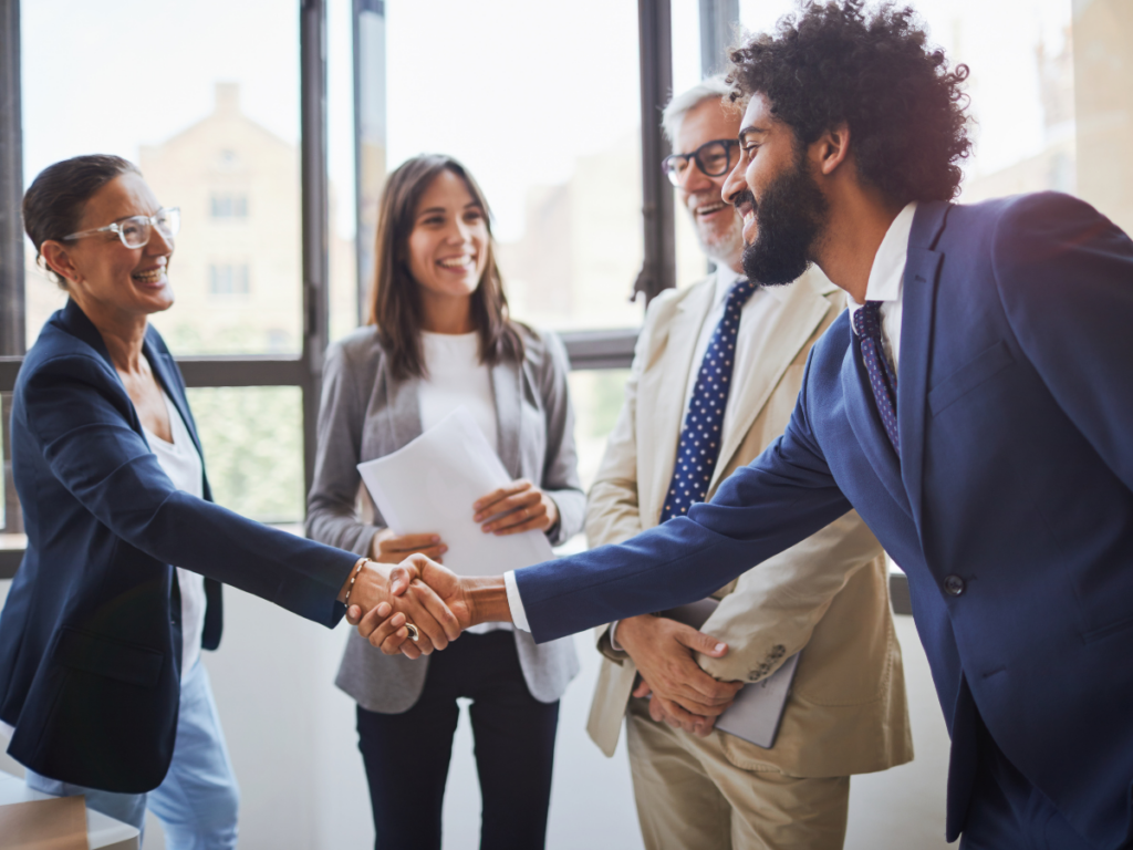 A group of people meeting and shaking hands. Learn what an RFP is, how to create one, and how technology can streamline your RFP process.